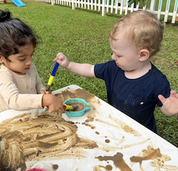 Nila and Arthur trying out the mud paint!