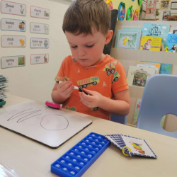Jamie exploring the letter sounds on the pop it.