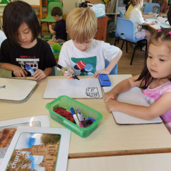 The children enjoying drawing and writing together.