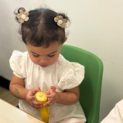 Skyla very focused on peeling a banana