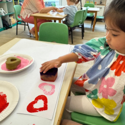 Eden getting ready for Valentines Day with heart shape prints craft. 