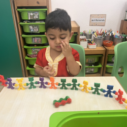 Kai enjoying table top activity, trying to create a pattern . 