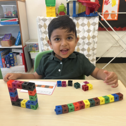 Kai having fun with cubes, making a square.