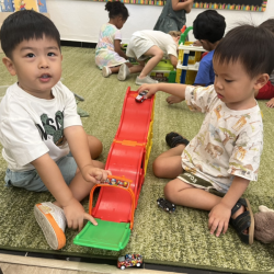 Wesley and Nate having fun trying the speed the each cars down the ramp. 