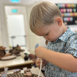 Noah working on threading some animals beads!