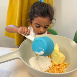 Sara helping to pop the ingredients into the mixing bowl!