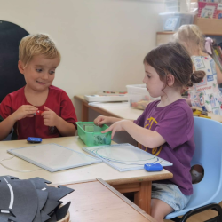 Joshie and Evie discussing what to draw. 