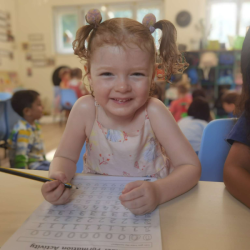 Kate is all smiles to practise her writing.