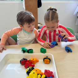 Focused little hands at work exploring colorful number puzzles.