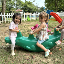 Constance, Immy, and Harper rocking the see-saw—up, down, and all around with giggles galore! 
