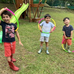 Luca, Alex and Lincoln having fun in the garden with hula hoops.