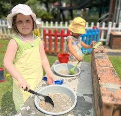 Paige having a great time at the mud kitchen.