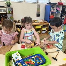 Vivi , Paige and Ei practicing their fine motor skills,  hammering the wooden blocks and needles.
