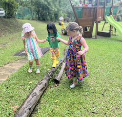Izzy and Paige helping Toria to balance  on the log.