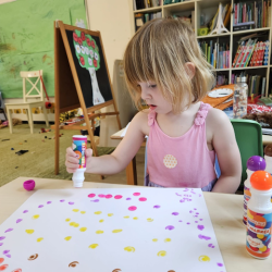Clara enjoying her art work with dots.