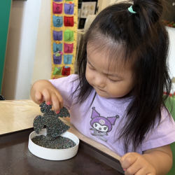 Annie decorating her ornament with glitter!