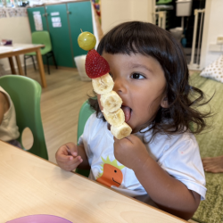 Lulu enjoying his snowman fruit kebab!