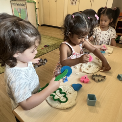 Sara and Cru exploring our glitter Playdough using Christmas cookie cutters!