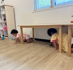 Una and Amara having lots of fun crawling under the table!