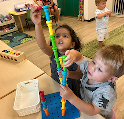 Una and Archer working together to make a big tower.