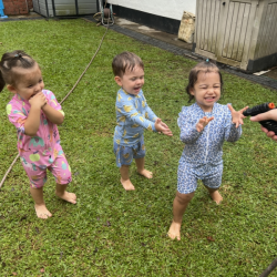 Alba and Luca enjoying being sprayed by the hose!