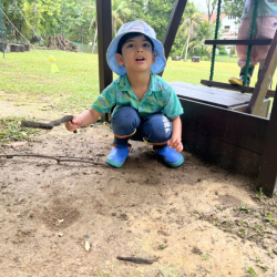 Archish pretending to make fire using a stick.