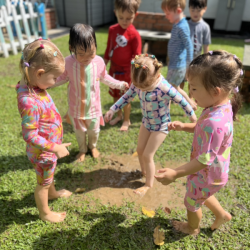 Girls enjoying the muddy puddle .