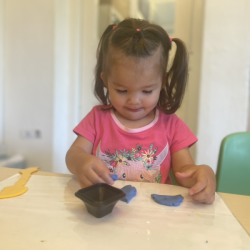 Tahlia is enjoying playing with play dough.