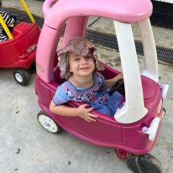 Annabel is having fun in the pink car.