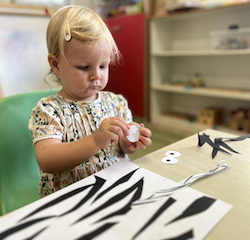Eleanor working on her final part of her zebra craft - pasting the eyes!