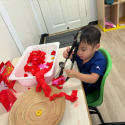 Mateo using tongs in our tactile tray play!