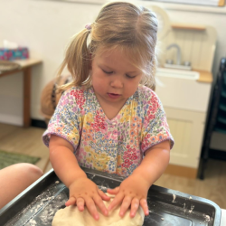 Olivia patting the salt dough making it nice and firm!