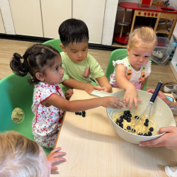 Nysha, Wesley and Eleanor popping blueberries in the muffin mixture!